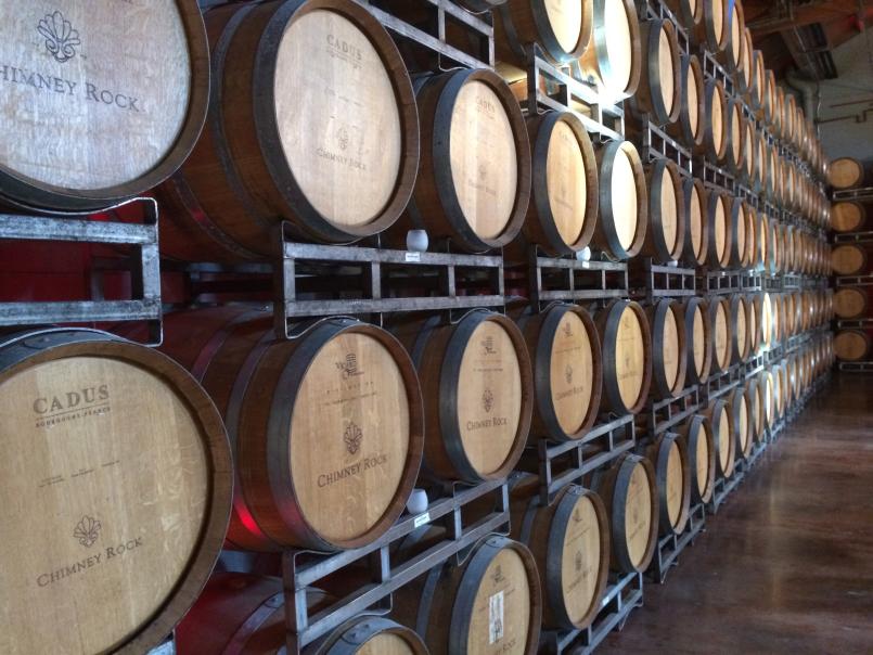Petits tonneaux de vin entreposés les uns sur les autres dans une cave